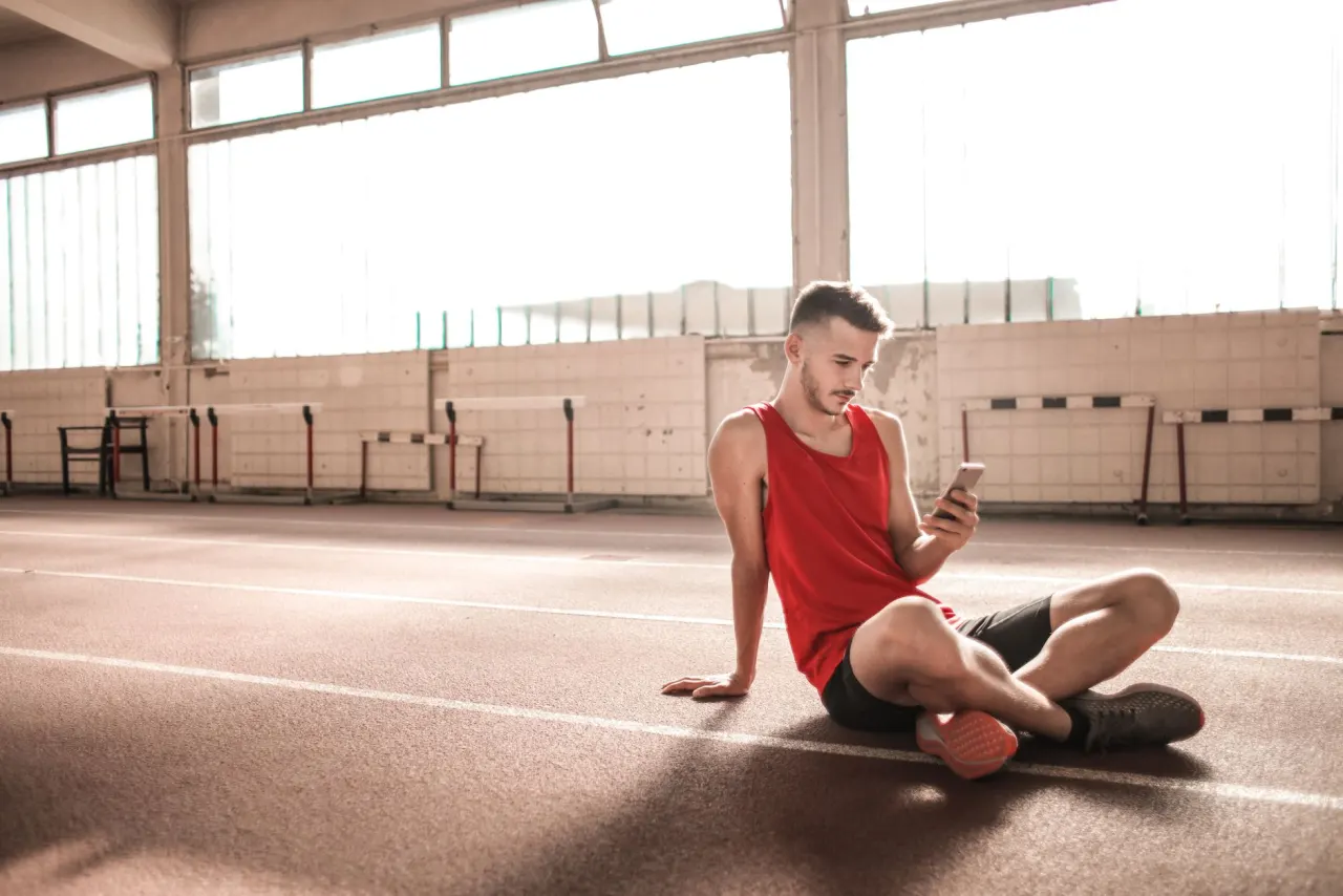 Athlete checking a training app on a phone before a workout.