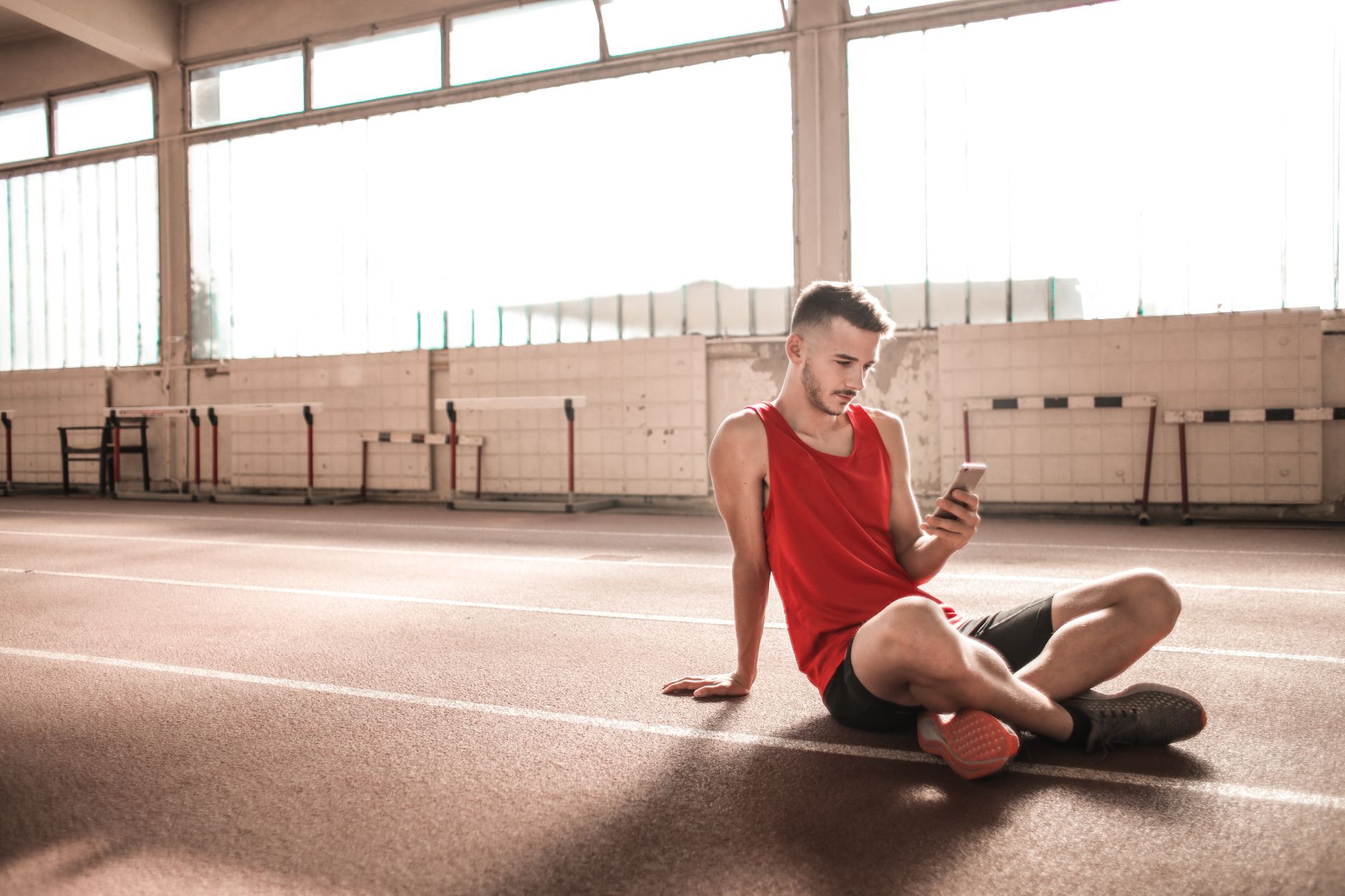Athlete checking a fitness app on a phone for How to choose an adaptive training app without buying a black box.