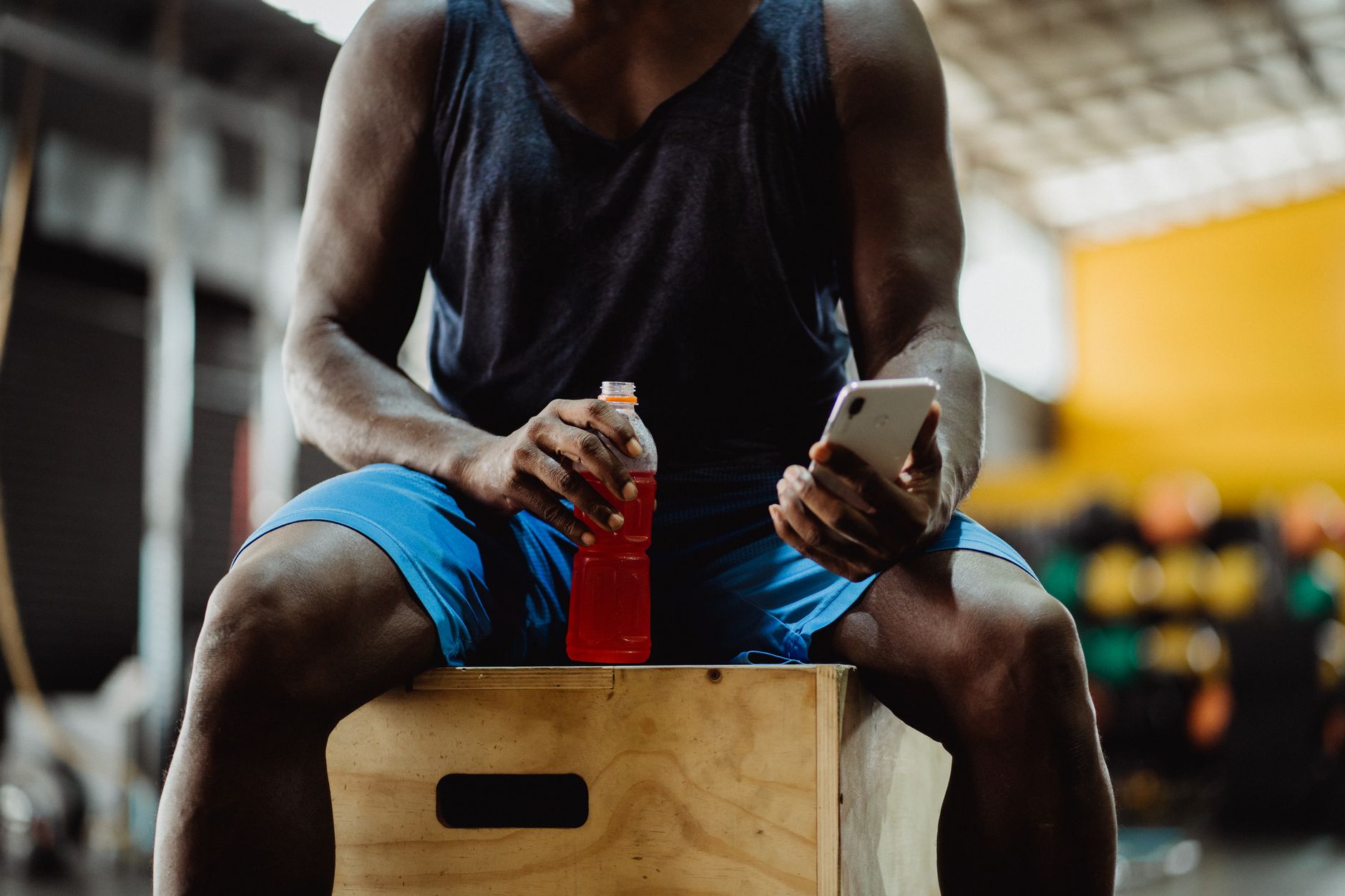 Athlete checking a fitness app on a phone for Best training app for weekly personalization.