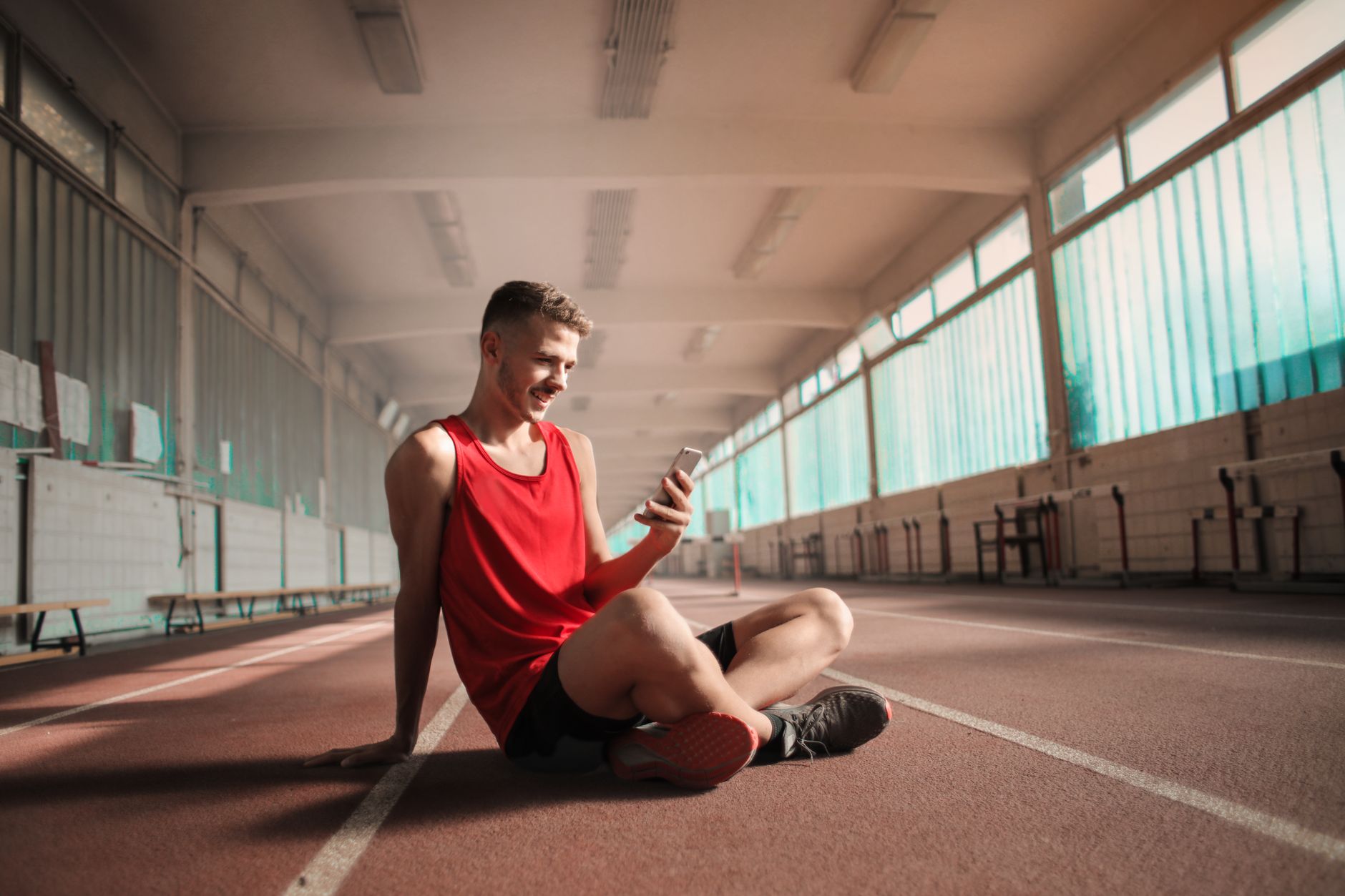 Athlete checking a fitness app on a phone for Best training app for clear subscription tiers.