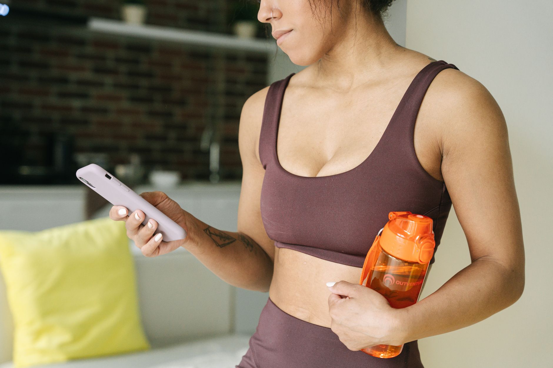Athlete checking a fitness app on a phone for Best training app with admin and support request visibility.